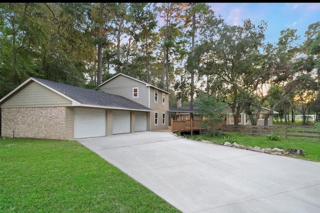 front of property with a garage, a deck, and a lawn