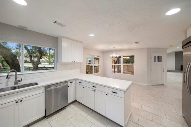 kitchen with sink, white cabinets, backsplash, kitchen peninsula, and stainless steel appliances