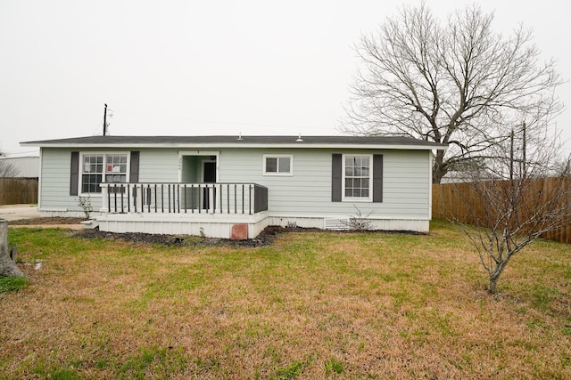 back of property featuring a deck and a lawn