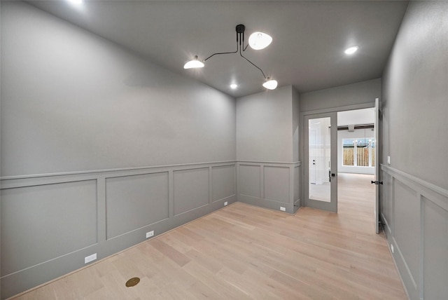 8545 Ridgepoint Dr, Houston, TX 77055 - empty room featuring a decorative wall, light wood-style flooring, wainscoting, and recessed lighting