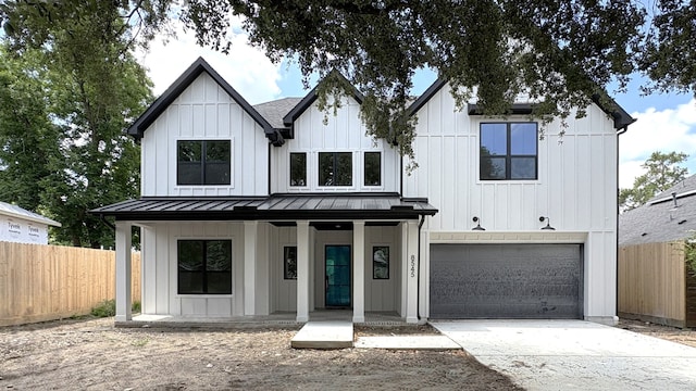 8545 Ridgepoint Dr, Houston, TX 77055 - modern farmhouse style home featuring a porch, a standing seam roof, a garage, concrete driveway, and board and batten siding