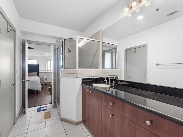 bathroom featuring vanity, a shower with door, and tile patterned flooring