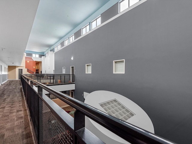 corridor with carpet floors and a high ceiling