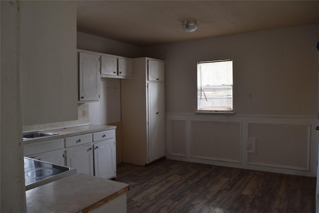 kitchen featuring dark hardwood / wood-style flooring, sink, and white cabinets