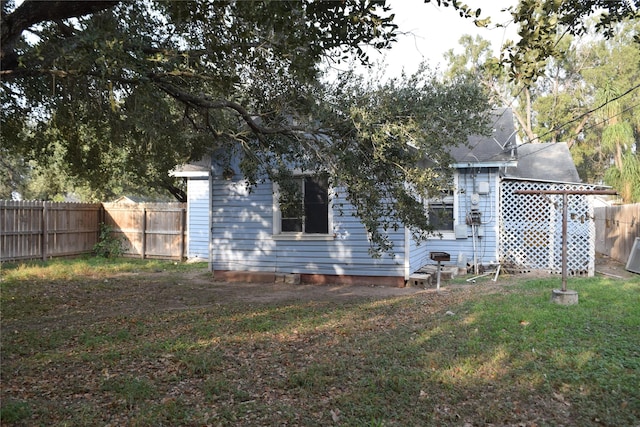 back of house featuring a lawn