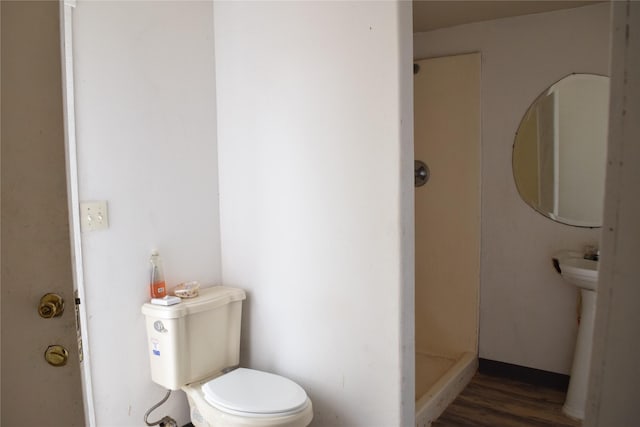 bathroom featuring hardwood / wood-style flooring, toilet, and walk in shower