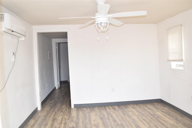 spare room with dark wood-type flooring, a wall unit AC, and ceiling fan