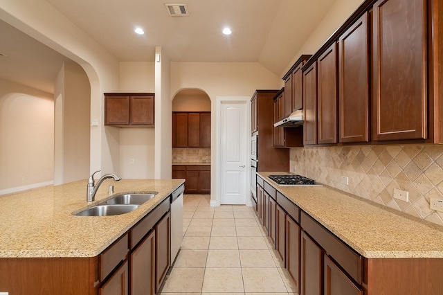 kitchen with sink, light tile patterned flooring, light stone countertops, and appliances with stainless steel finishes