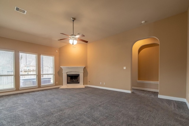 unfurnished living room featuring dark carpet, vaulted ceiling, and ceiling fan