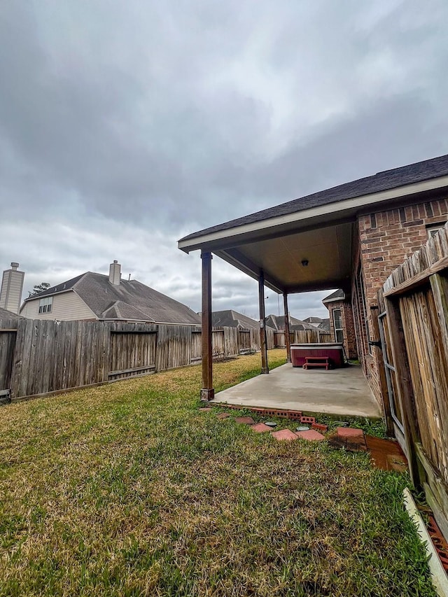 view of yard with a patio area and a hot tub