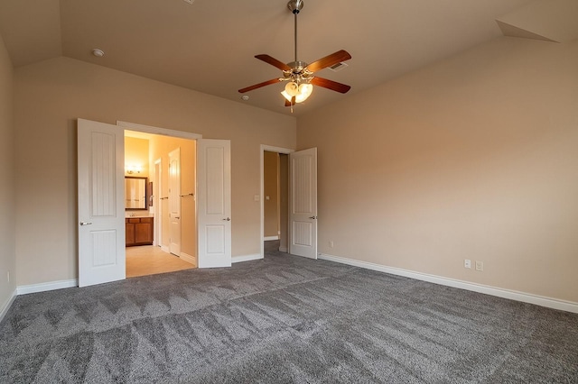 unfurnished bedroom featuring ceiling fan, lofted ceiling, carpet flooring, and connected bathroom