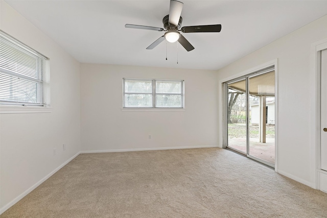 carpeted spare room featuring plenty of natural light and ceiling fan