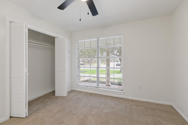 unfurnished bedroom with light carpet, ceiling fan, and a closet