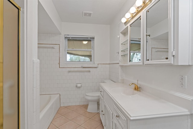 full bathroom featuring tile patterned floors, toilet, tile walls, vanity, and tiled shower / bath combo