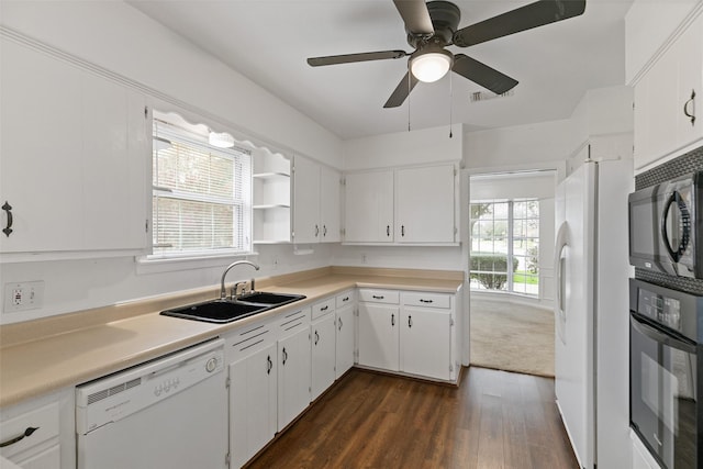 kitchen featuring white cabinets, a healthy amount of sunlight, sink, and black appliances