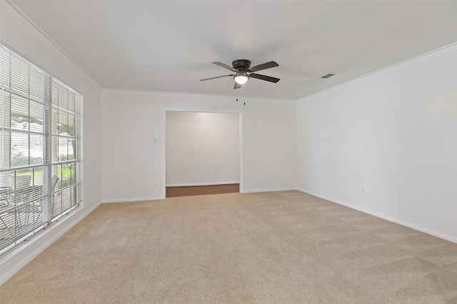 spare room featuring ornamental molding, light carpet, and ceiling fan