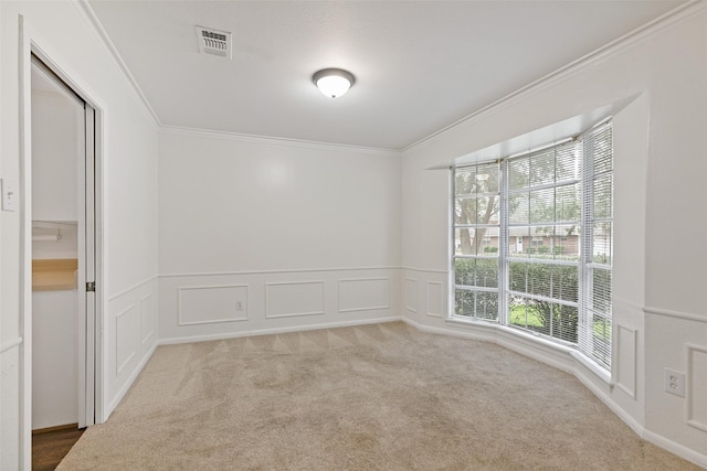 unfurnished room with crown molding and light colored carpet