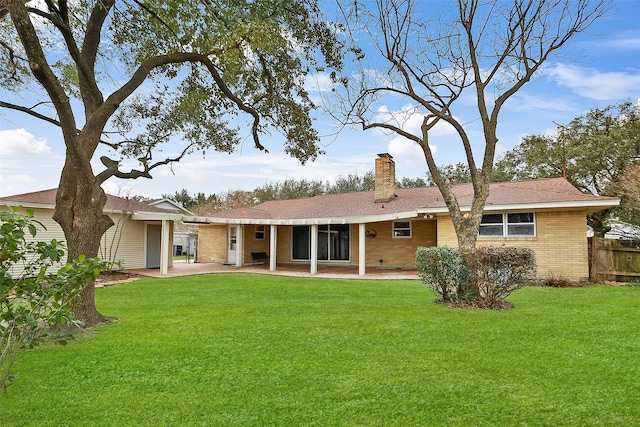 rear view of house featuring a yard and a patio area