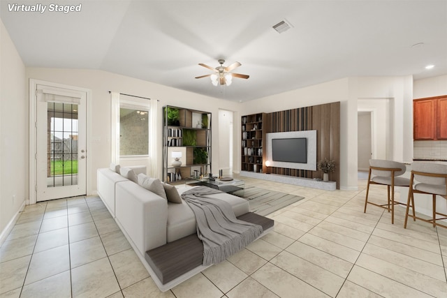 living room featuring light tile patterned flooring, lofted ceiling, and ceiling fan