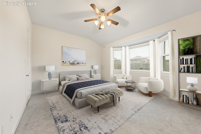 bedroom with ceiling fan, light colored carpet, and vaulted ceiling