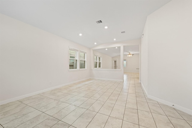 spare room featuring vaulted ceiling, light tile patterned floors, and ceiling fan