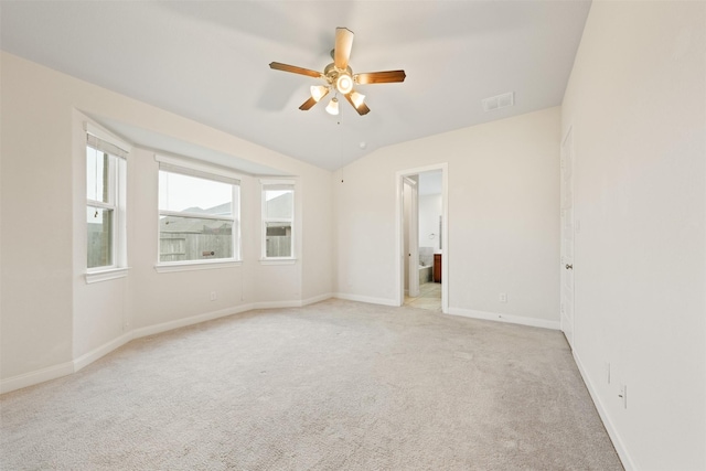 carpeted spare room with vaulted ceiling and ceiling fan