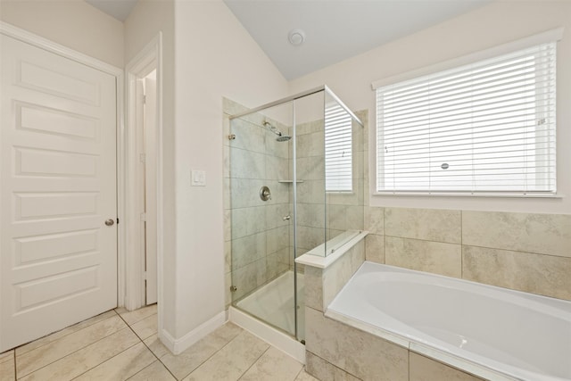 bathroom featuring tile patterned flooring, shower with separate bathtub, and vaulted ceiling