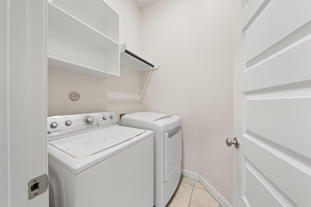 laundry room featuring washer and clothes dryer and light tile patterned flooring