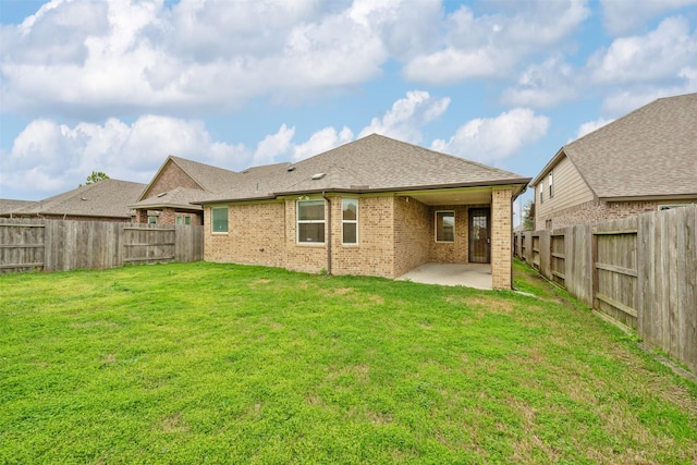 rear view of house featuring a lawn and a patio