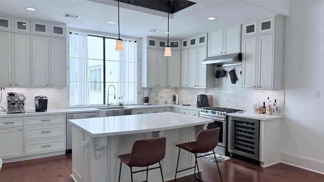 kitchen featuring appliances with stainless steel finishes, sink, a kitchen island, and white cabinets