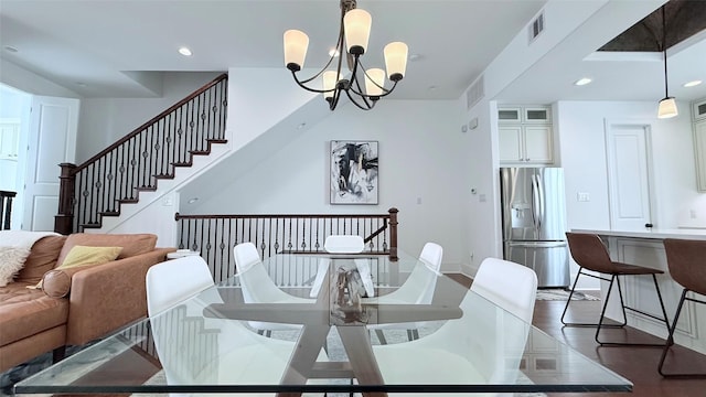 dining area with dark hardwood / wood-style floors and a notable chandelier