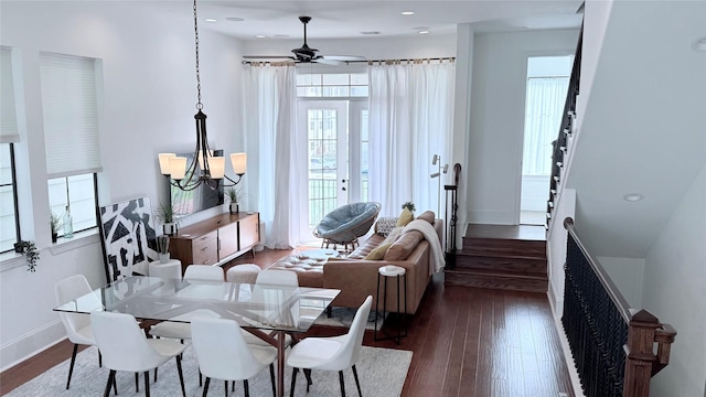 dining space with dark hardwood / wood-style flooring and ceiling fan with notable chandelier