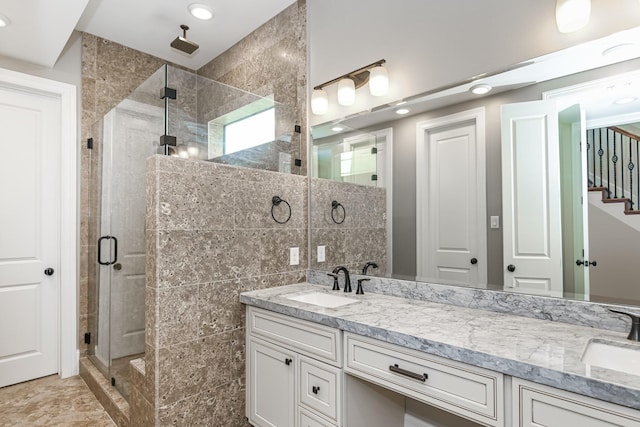 bathroom featuring vanity, a shower with shower door, and tile walls