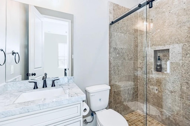 bathroom with vanity, toilet, and a shower with shower door