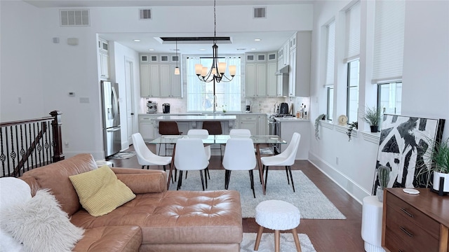 dining room with an inviting chandelier, hardwood / wood-style floors, a wealth of natural light, and sink