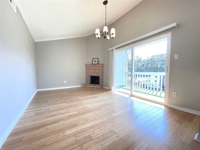 unfurnished living room featuring baseboards, light wood finished floors, a fireplace, and an inviting chandelier