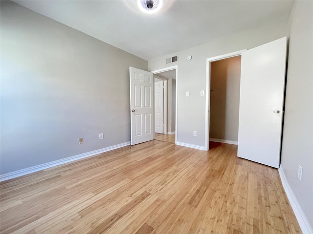 unfurnished bedroom with baseboards, visible vents, and light wood finished floors