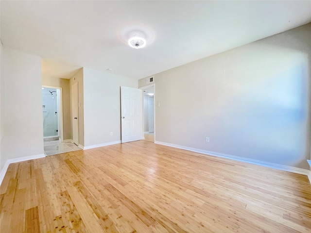 interior space featuring light wood-type flooring, visible vents, and baseboards