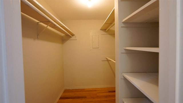 walk in closet with wood finished floors