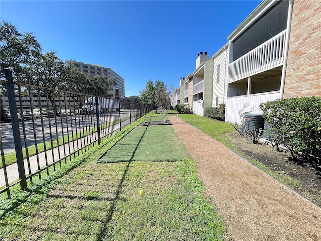 surrounding community featuring a residential view, fence, and a lawn