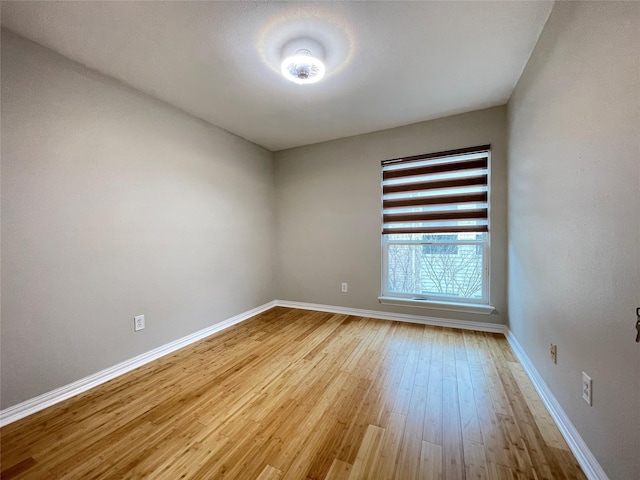 empty room with light wood finished floors and baseboards