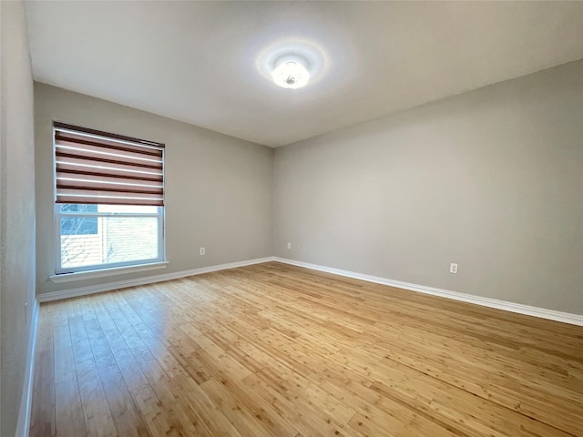 unfurnished room with light wood-style flooring and baseboards