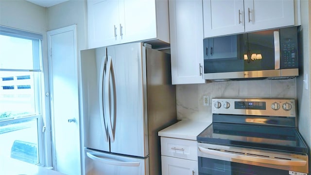 2300 Augusta Dr Unit 22, Houston, TX 77057 - kitchen featuring white cabinets, stainless steel appliances, decorative backsplash, and light countertops