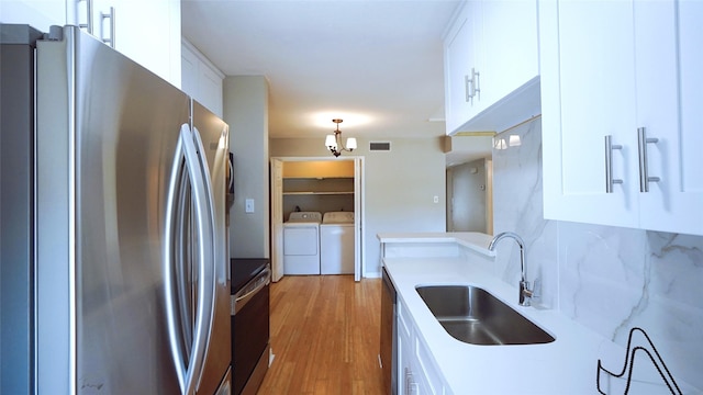 2300 Augusta Dr Unit 22, Houston, TX 77057 - kitchen with range, a sink, white cabinets, freestanding refrigerator, and separate washer and dryer