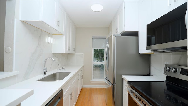 2300 Augusta Dr Unit 22, Houston, TX 77057 - kitchen with appliances with stainless steel finishes, a sink, light wood-style floors, and white cabinets