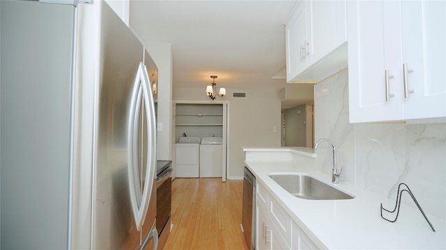 2300 Augusta Dr Unit 22, Houston, TX 77057 - kitchen with appliances with stainless steel finishes, a sink, light wood-style floors, white cabinets, and light countertops