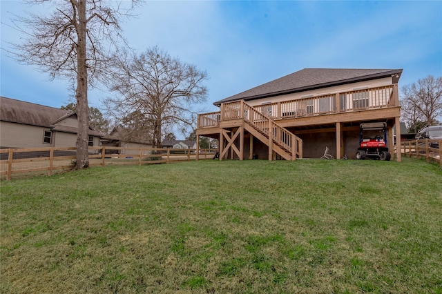 back of house featuring a deck, a fenced backyard, a shingled roof, stairway, and a lawn