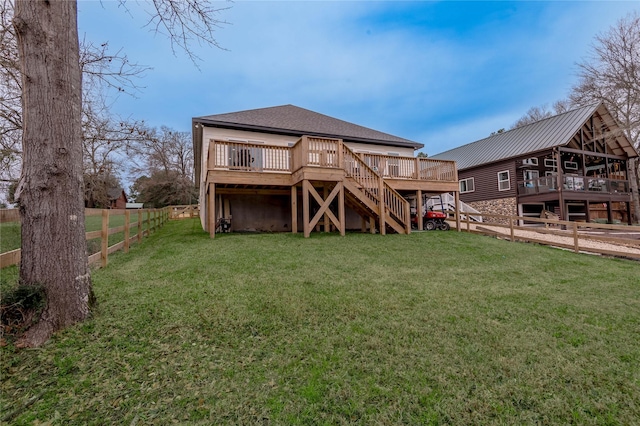 rear view of house with roof with shingles, a lawn, a deck, a fenced backyard, and stairs