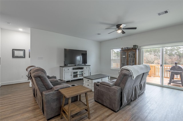 living room featuring light wood-style floors, baseboards, visible vents, and a ceiling fan