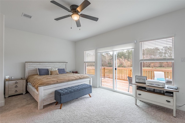 carpeted bedroom with access to exterior, ceiling fan, and visible vents